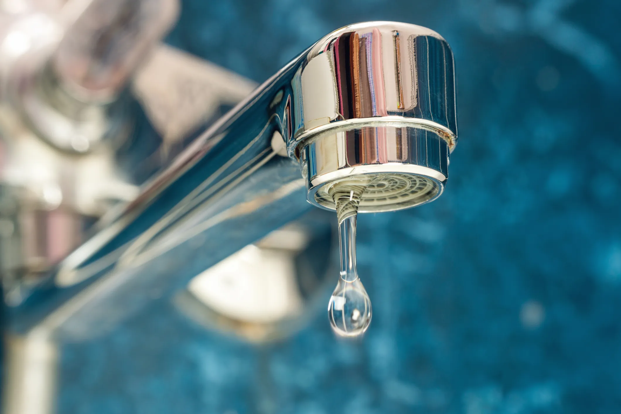 A drop of water drips from a leaky faucet.